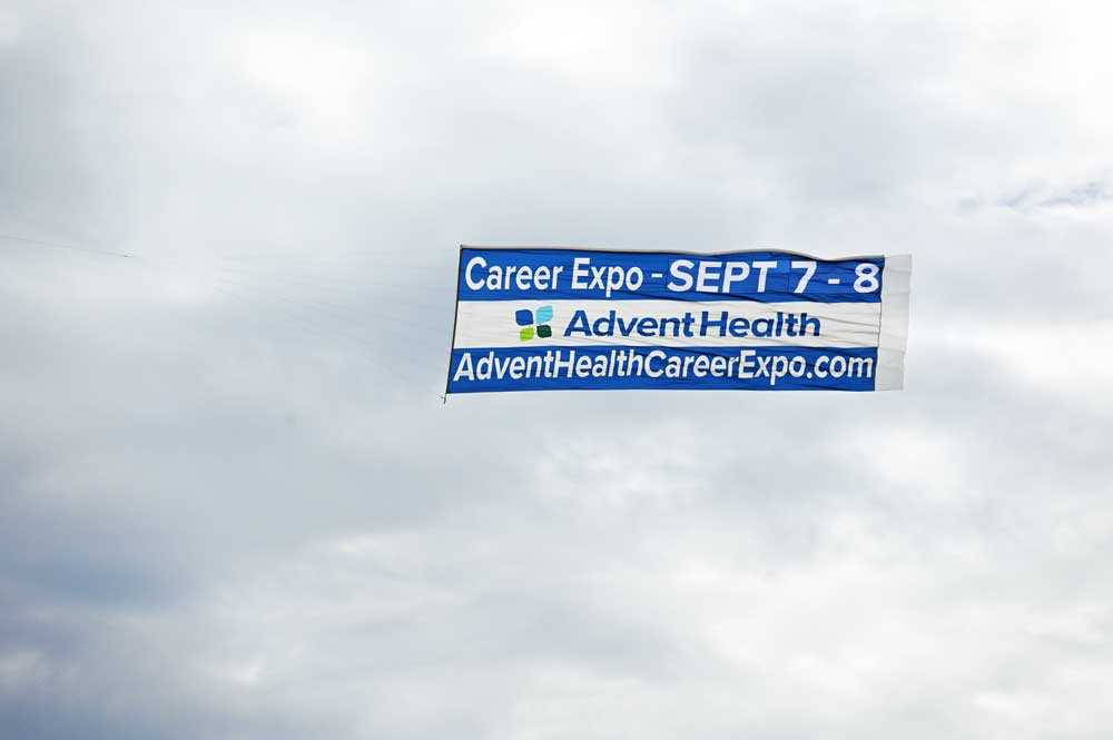 AdventHealth hired a plane to advertise its career expo over the sands of Flagler Beach on Saturday. (© FlaglerLive)