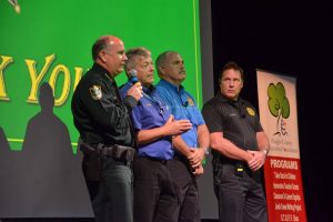 Carman and Sgt. Mike Lutz, second from left, developed an elaborate active-shooter drill into a show they put on for scores of audiences. They're seen here at one such drill for 1,000 Flagler County school faculty members last fall, with Sheriff Rick Staly and homeland security director Randall Stroud. (© FlaglerLive)