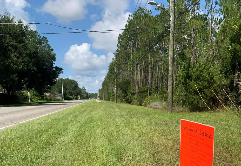 The tip of the required sign announcing the coming hearing before the Palm Coast Planning Board on the land use changes that would enable the development of up to 850 residential homes and apartments on acres off of Seminole Woods Boulevard. (Palm Coast)