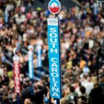 Caucusgoers stand beneath the sign for the South Carolina delegation at the Democratic National Convention.