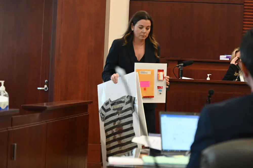 Assistant State Attorney Jennifer Dunton with the shirt Brandi Celenza wore when she was shot twice, and one of the bullets in the shooting. (© FlaglerLive)