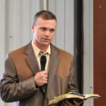 Charles L/ Cowart reading scriptures at a celebration of life for Sisco Deen in September 2023 at Cattleman's Hall at the Flagler County Fairgrounds. Deen had mentored Cowart. (© FlaglerLive)