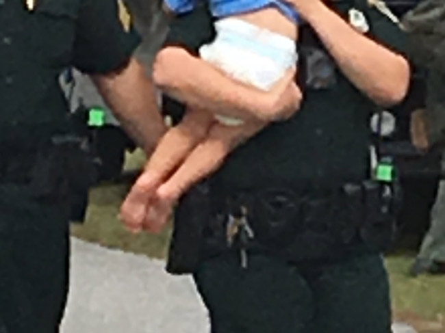 An image the sheriff's office released this afternoon of the rescue of the 2-year-old boy, who was not harmed, in the course of a domestic violence issue involving his parents on Parkview Drive this afternoon. (FCSO)