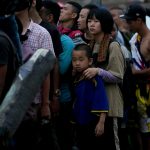 Chinese migrants wait for a boat after having walked across the Darien Gap from Colombia to Panama.