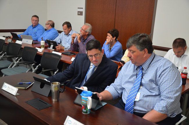 Palm Coast Finance Director Chris Quinn, in the foreground, with Beau Falgout, a senior member of the city administration, at a July 11 meeting. Two days later, Quinn  applied for a job in Gainesville. The rest of the city's directors are in the background. City Manager Jim Landon, referring to himself as 'their leader,' claimed last week that the council's discussions of his future was unsettling them, and that some of them might leave. (© FlaglerLive)