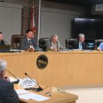 City Commissioners John Cunningham, first on let on the dais, and Rick Belhumeur, third from left, were prepared to leave the city without a budget if it went forward with a new engineering position. City Manager Dale Martin, foreground, left, proposed removing it and bringing back the position should it be needed later in the fiscal year. Others on the dais, from left, were Chair James Sherman, Commissioner Scott Spradley and Mayor Patti King. (© FlaglerLive)