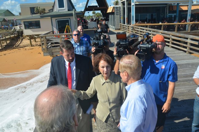 An image from last year's visit by Sen. Bill Nelson, after Hurricane Matthew, that aptly captured the hierarchy of levers, with Craig Coffey, the county administrator, next to then-County Commissioner Barbara Revels, in the foreground, with Nelson, and Steve Garten in the far distance, behind IT Director Jarrod Shupe to the left. (c FlaglerLive)