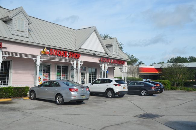 The shooting took place shortly after midnight this morning in front of the smoke shop and coin laundry off Belle Terre Parkway. It was business as usual there this morning. (c FlaglerLive)