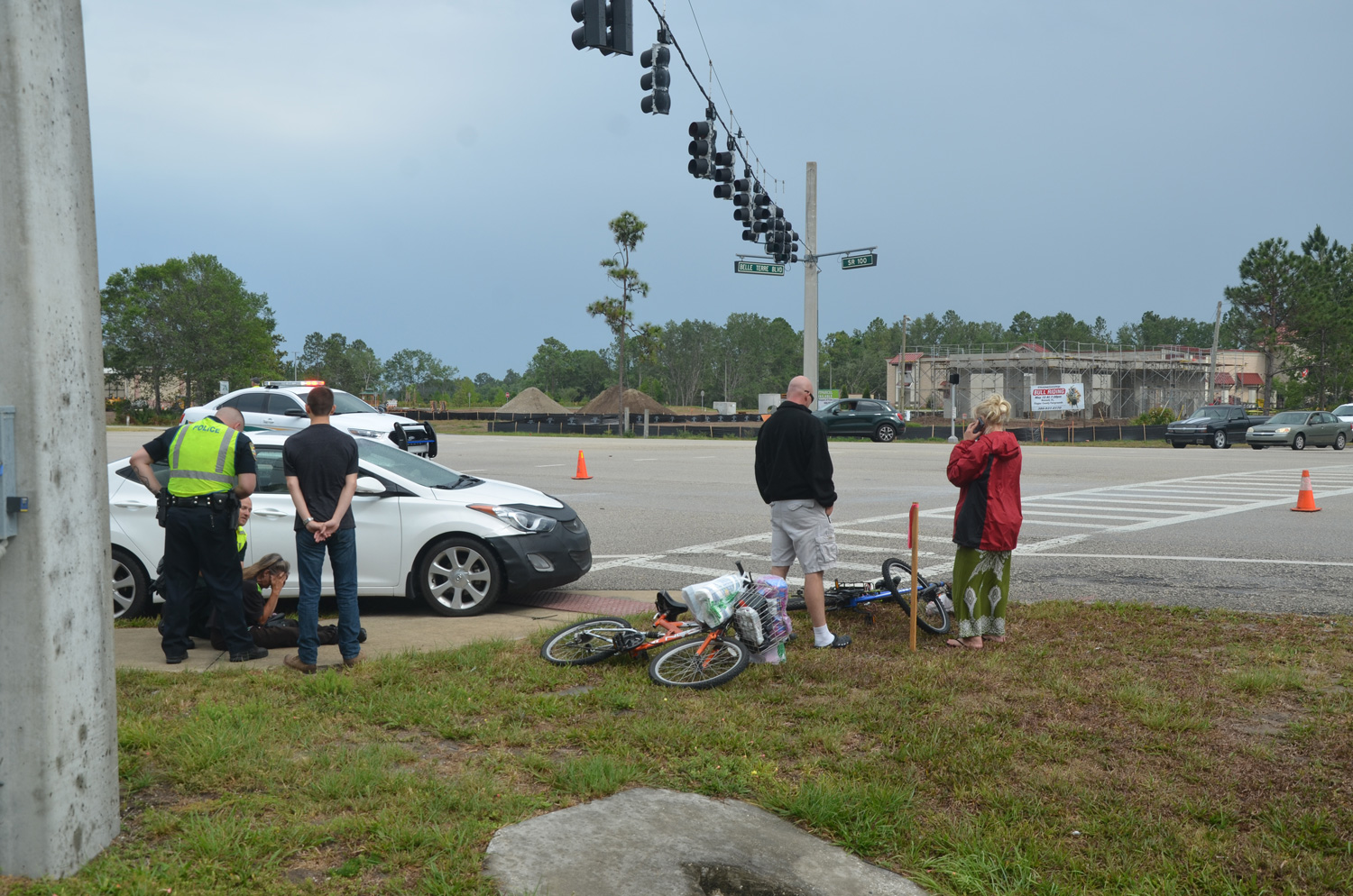 The cyclist's roommate, left, arrived at the scene about half an our after the crash and was greatly distraught, eventually requiring the intervention of paramedics, but she was not taken to a hospital. Her bicycle is in the foreground, the victim's, which was struck, is nearer the road. Click on the image for larger view. (c FlaglerLive)