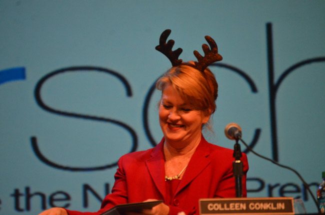 Flagler County School Board member Colleen Conklin was all elved up for Tuesday evening's board m eeting at the Flagler Auditorium. She was also the surprise recipient of a special recognition from Flagler Volunteer Services for her herculean efforts helping Flagler Beach neighbors flooded out after Hurricane Irma. (© FlaglerLive)