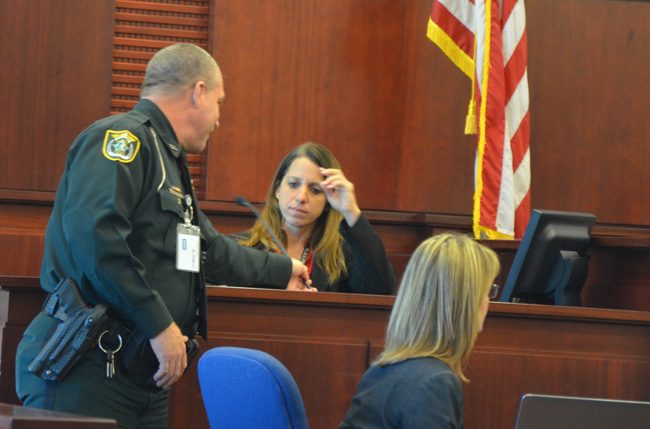 Flagler County Sheriff's Detective Annie Conrad preparing to testify in a murder trial last month. Her role in the case, which led to a conviction for first degree murder, was cited among the reasons she was named Law Enforcement Officer of the Year. But she has been on  medical leave for weeks due to sickness she attributes to the sheriff's Operations Center. (c FlaglerLive)