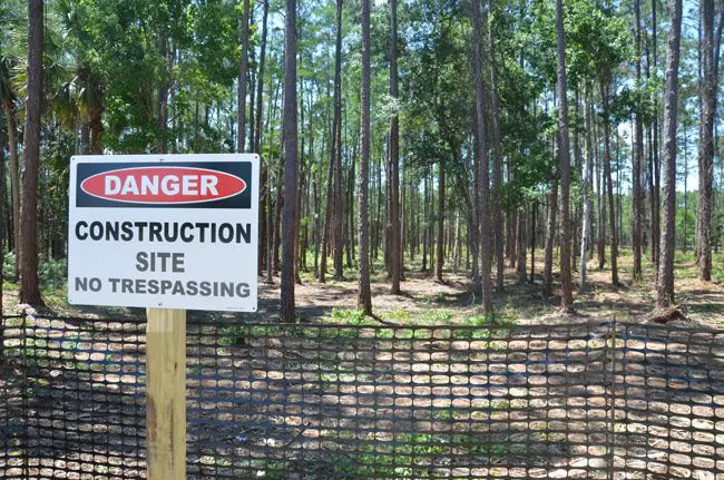 The former homeless  camp near the library has been razed of human beings and replaced with a no-trespassing sign even though no construction has yet been approved, or permitted. (© FlaglerLive)