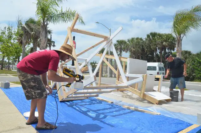 Eric Cooley, left, and Commissioner Rick Belhumeur last Saturday, painting the first two of nine lifeguard towers. Additional volunteers lent a hand during the week to get the towers painted. (© FlaglerLive)
