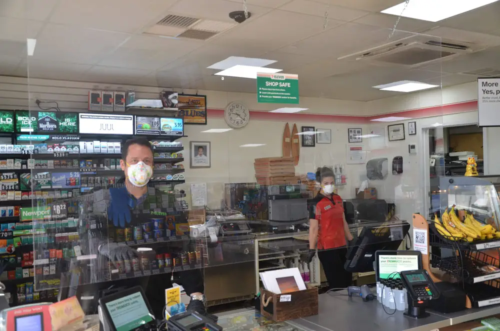Flagler Beach City Commissioner Eric Cooley, behind mask and plexiglass at the 7-Eleven he owns in the city, isn't interested in becoming a mask policeman anymore than is Sheriff Rick Staly. (© FlaglerLive)