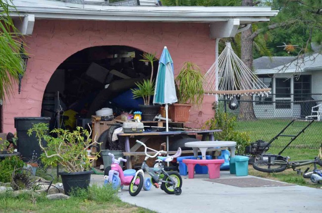 The garage area at 1 Cooper Lane, a mixture of toys and more aged clutter, immediately after authorities left the property Friday afternoon. (c FlaglerLive. Click on the image for larger view.)