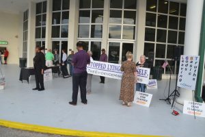 Charlene Cothran, left, and her group this evening at the entrance to the GSB. (© FlaglerLive)