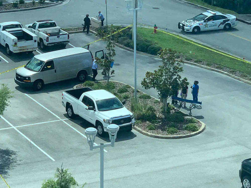 The scene at the courthouse parking lot, within view of the Government Services Building and of courtrooms, some of them in session, in late morning as the Medical Examiner was preparing to remove the victim. (© FlaglerLive)