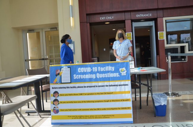 Julie Anderson, left, and Sue Collister, county employees, at the covid checkpoint at the courthouse this morning. (© FlaglerLive)