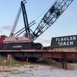 The contractor had been building a steel platform, or trestle, to parallel the pier, using it to shuttle machinery and equipment to demolish the old structure, when the work stopped because of nesting turtles. The crane was waiting to resume work a few days ago. The go-ahead was issued today. (© Rick Belhumeur for FlaglerLive)