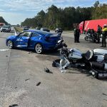 Flaglerr County Sheriff's deputy Benjamin Stamps was on his motorcycle when the blue car swerved into the emergency lane Stamps was riding, provoking a collision that left the deputy with severe injuries. (FCSO)