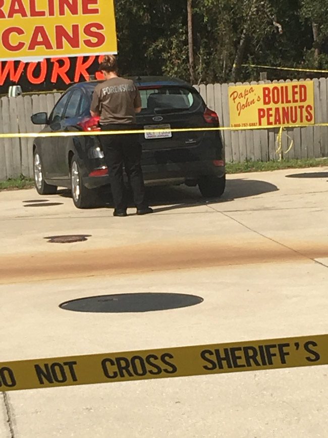 A crime-scene technician analyzing the victim's vehicle. (© FlaglerLive)