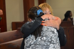 Carol Eure hugs Rebecca Crowley, who'd been the victim of the Sharps Liquor robbery. Eure was with Crowley as both attended every step of the case as it made its way to trial. Click on the image for larger view. (© FlaglerLive)