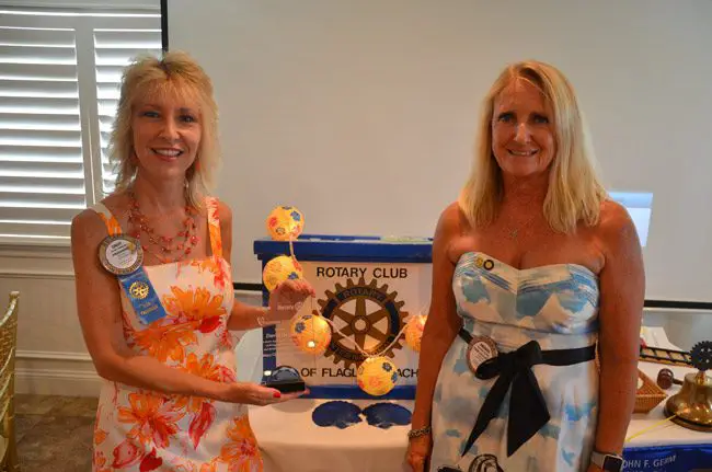 Cindy Dalecki, left, with the Flagler Beach Rotary's new Volunteer of the Year Award, which earlier this month was awarded to the late Dave Dalecki, Cindy';s husband. The award is to be known henceforth as the Dave Dalecki Volunteer of the Year Award. Cindy Dalecki is the Rotary's past president. Amanda Bailey, right, was installed as this year's president. Roseanne Stocker was named the Rotarian of the Year and Tom DeCeglie the Citizen of the Year. (© FlaglerLive)