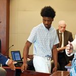 Da'Mari Barnes, center, in court today after tendering his plea, with his attorney, Steven Robinson, behind him, and Knoeidia Hill, a victim's advocate with the State Attorney's Office, right, standing with parents of the victim. (© FlaglerLive)