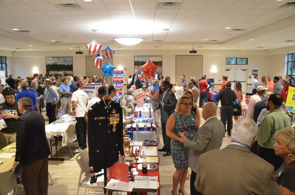 Danielle Anderson, at a campaign event last year (center), heads the Flagler County Republican Club and is a correspondent for the News-Journal. (© FlaglerLive)