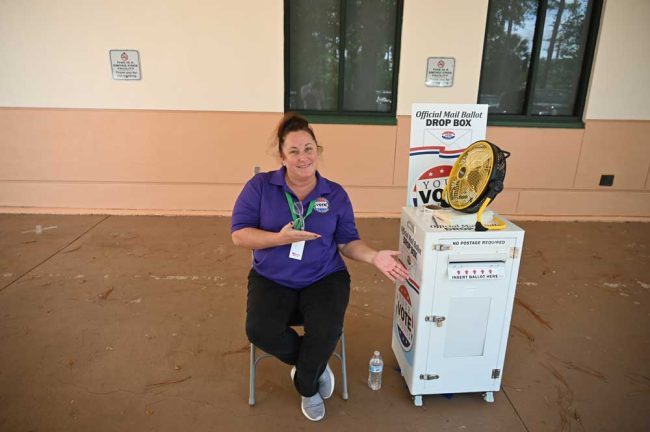 The indefatigable Danielle Anderson, wearer of a few hundred hats (among others, as editor of Flagler News Weekly), here logging in civic-duty time as guardian of the drop box at the county library. (© FlaglerLive)