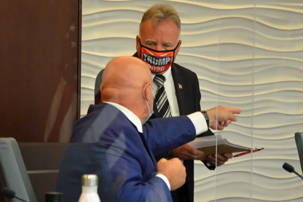 Palm Coast Council member Eddie Branquinho telling fellow-Council member Ed Danko to get away from him after the meeting today. (© FlaglerLive)