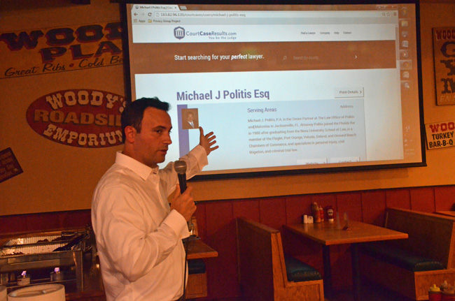 CourtCaseResults.com's Darren McGuire walking guests through the website's functions at its launch party at Woody's BarBQ Monday evening. (© FlaglerLive)