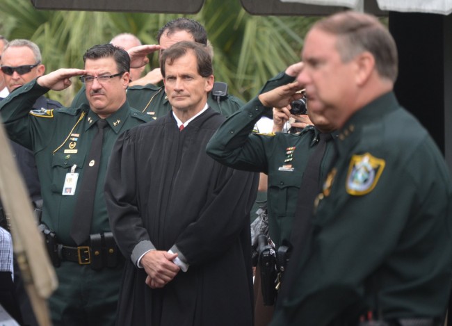 David O'Brien, saluting next to Flagler County Circuit Judge Dennis Craig, during Sheriff Manfre's swearing-in last January. Staly is in the foreground, to the right. Click on the image for larger view. (© FlaglerLive)