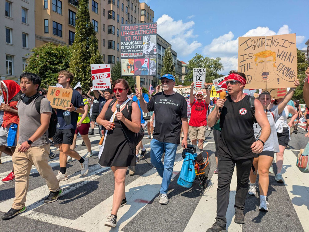 Marchers sang protest songs and led “Trump must go now” chants as they walked down 16th Street NW in Washington, D.C., on Sept. 6, 2025, during the “We Are All DC” demonstration against the deployment of National Guard troops in the nation’s capital. (Photo by Ashley Murray/States Newsroom)