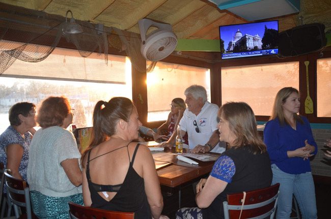 Flagler's Young Democrats, organized by Michelle Atack, right, met at Hidden Treasures in Flagler Beach Thursday evening for a debate watch party. Many more in attendance are sitting out of view. The first group of Democratic presidential candidates debated in Miami Thursday evening. The second group debates tonight. (© FlaglerLive)