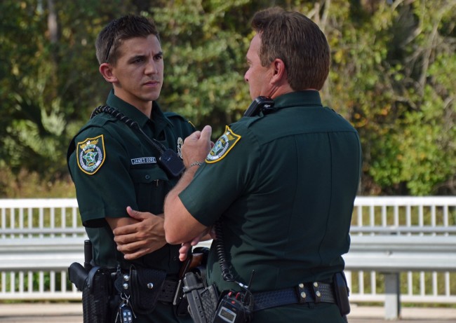 Deputy James Gore, left, speaking with Cmdr. Mark Carman at the scene. Click on the image for larger view. (© FlaglerLive)