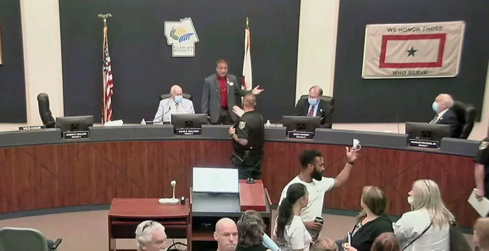 A flagler County Sheriff's deputy intervened as Commissioner Joe Mullins was insulting fellow-Commissioner Greg Hansen, to the right of Mullins on the dais, Wednesday during a commission meeting. Mullins later wanted to lodge a complaint against a deputy even as he spoke from the dais about the importance of supporting law enforcement. (© FlaglerLive via YouTube)
