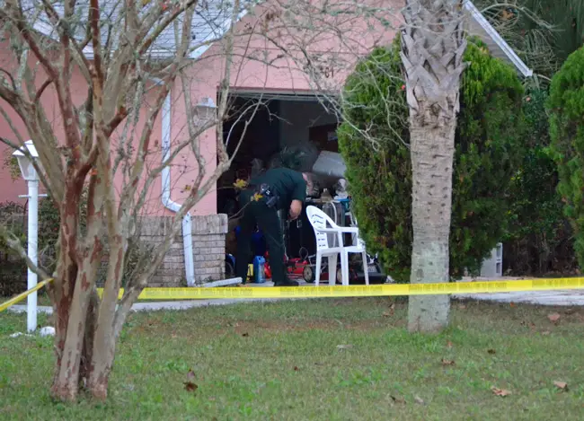 A Flagler County Sheriff's deputy examines the garage where deputies had earlier that day shot and killed Troy Gordon, a 32-year-old resident of the house. (© FlaglerLive)