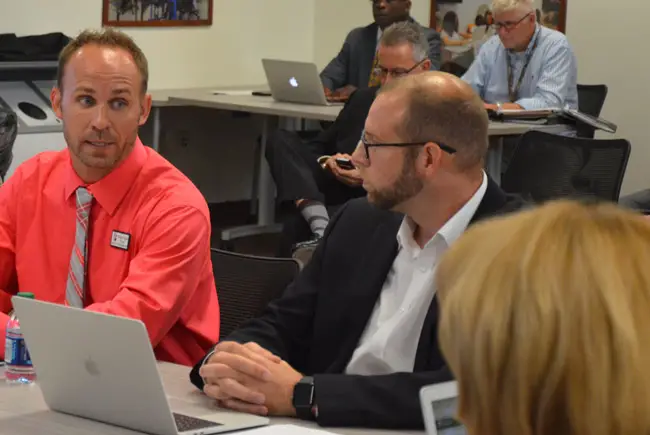 Ryan Deising, the Flagler school district's IT director, speaking to the school board this afternoon with Benjamin Osypian, principal at Old Kings Elementary, about various aspects of the district's technology initiatives. (© FlaglerLive)