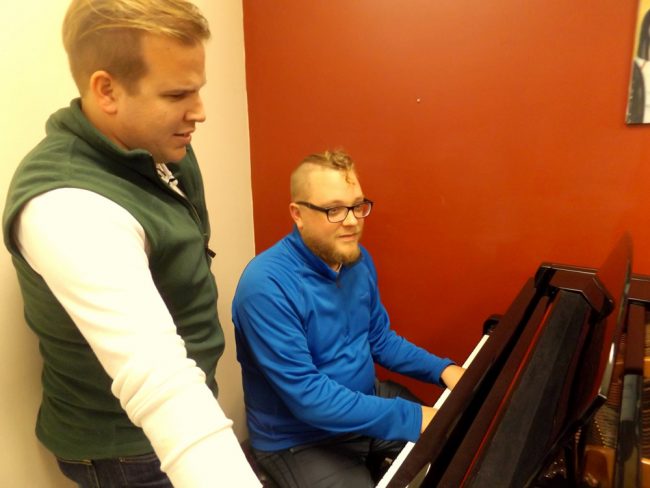 Director Tyler Adcock, left, and music director Ben Beck peruse the score of “Songs for a New World.” The 1995 “song cycle” will be staged Friday Jan. 12 through Jan. 28 at City Repertory Theatre in Palm Coast. (© FlaglerLive)