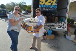 Shannon McCurdy of Palm Coast hands off a batch of donations to Flagler Broadcasting's Kirk Keller this morning at Winn-Dixie. (c FlaglerLive)