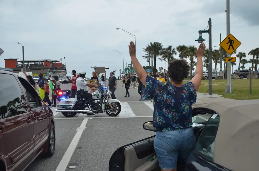 A woman taking the "don't shoot" stand in solidarity with marchers protesting police brutality in Flagler Beach last week. (© FlaglerLive)