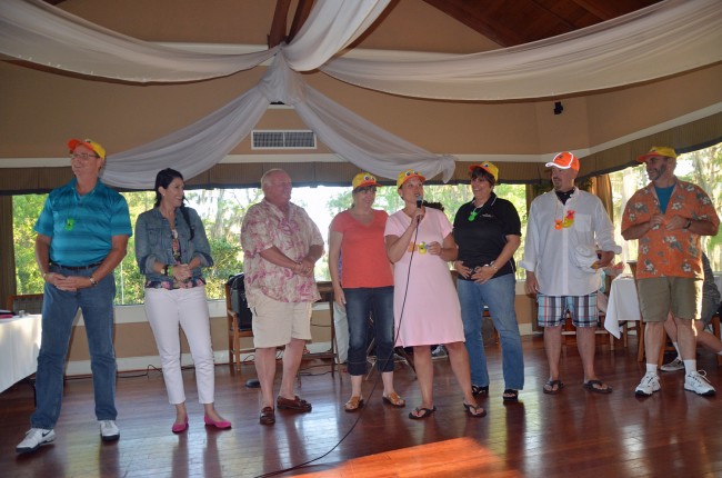 The Duck Dive's headliners. From left, Palm Coast Fire Chief Mike Beadle, former Commissioner Milissa Holland, Mayor Jon Netts, Flagler Chamber President Rebecca DeLorenzo, Tourist Development Director Georgia Turner, Flagler Beach Commissioner Kim Carney, Assistant Superintendent Jacob Oliva, and Auditorium Board Chairman Richard Hamilton. Click on the image for larger view. (© FlaglerLive)