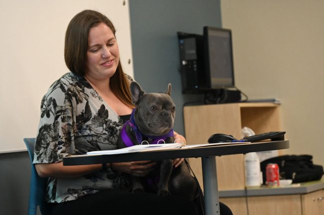 Flagler County Sheriff's detective Fiona Ebrill, who headed one of the panels, with Goose, the therapy dog. (© FlaglerLive)