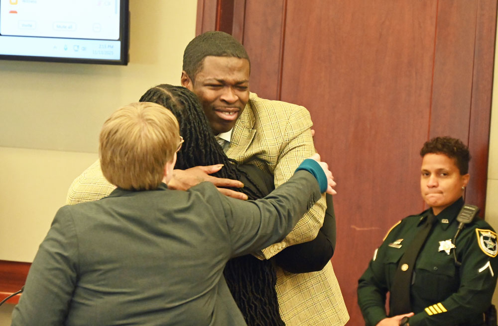 Edward "Ed Boy" Sampson hugging Assistant Public Defender CVourtney Davison, with Assistant Public Defender Melissa right behind her. (© FlaglerLive)