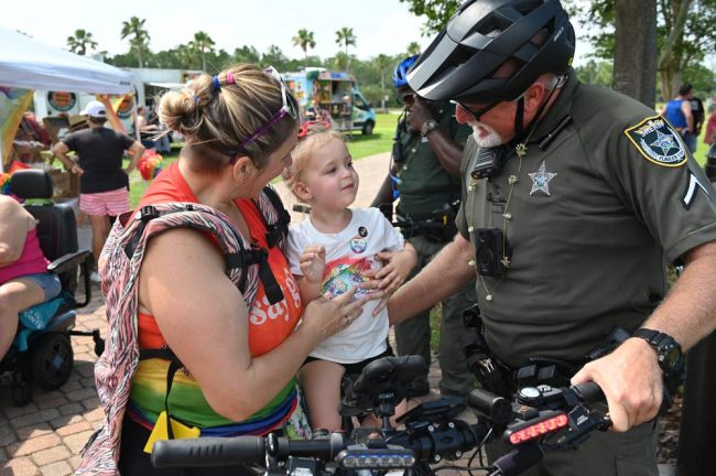 Eloise getting a quick ride on a Flagler County Sheriff's corporal's bike this afternoon, with her Mom, Erin Kunkel, of Ormond Beach. (© FlaglerLive)