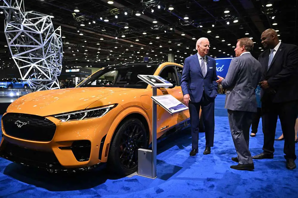 President Joe Biden speaks with Ford Motor Co. Executive Chairman William Clay Ford Jr. beside an electric Mustang. 