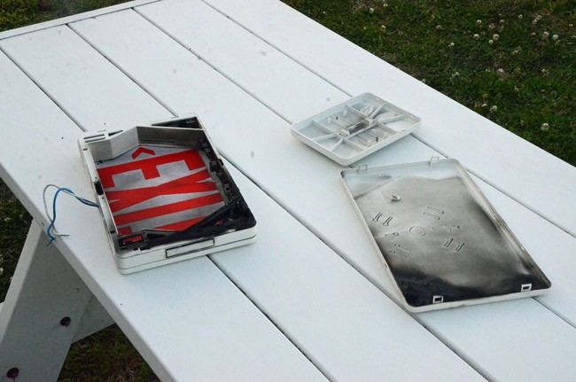 The faulty exit sign on a picnic table immediately after the fire this afternoon at EOC. (© FlaglerLive)