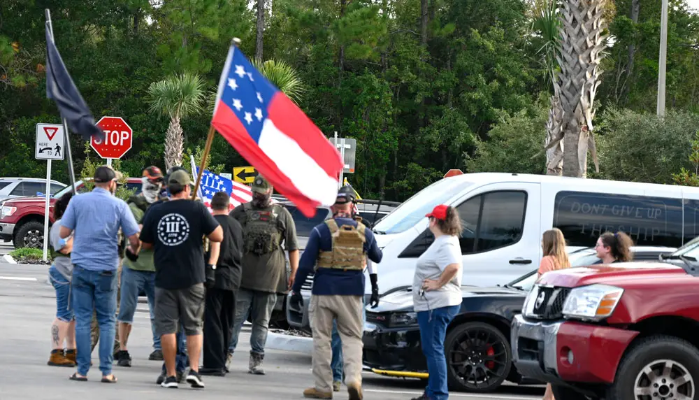 Far-right extremists, some in camouflage, some belonging to the Three Percenters, the anti-government militia, preparing to enter the Flagler County School Board meeting last month in Bunnell. (© FlaglerLive)