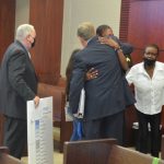 Benjamin Allen's mother immediately after the verdict hugs Gary Baker, the defense attorney who delivered closing arguments today, with Gerald Bettman, his other attorney, and his grandmother, standing by. (© FlaglerLive)